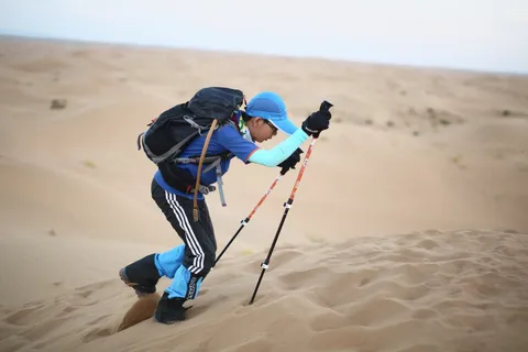 营员用登山杖攀上沙坡