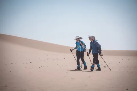 两名营员在沙地里并肩前行