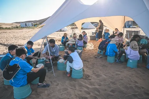 营员在营地天幕下休息用餐