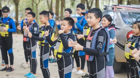 海南营员穿着救生衣与防寒服，在海边集合练习手势